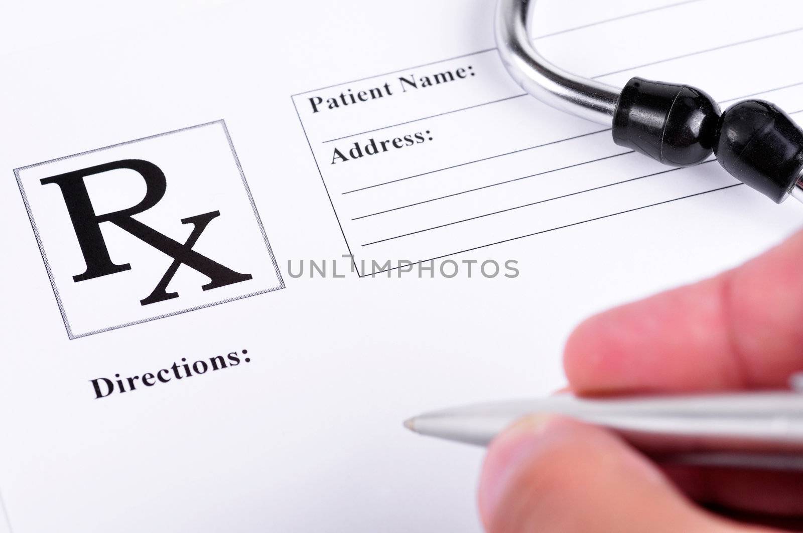 Medical prescription with a stethoscope on top of it and a doctor about to write on it