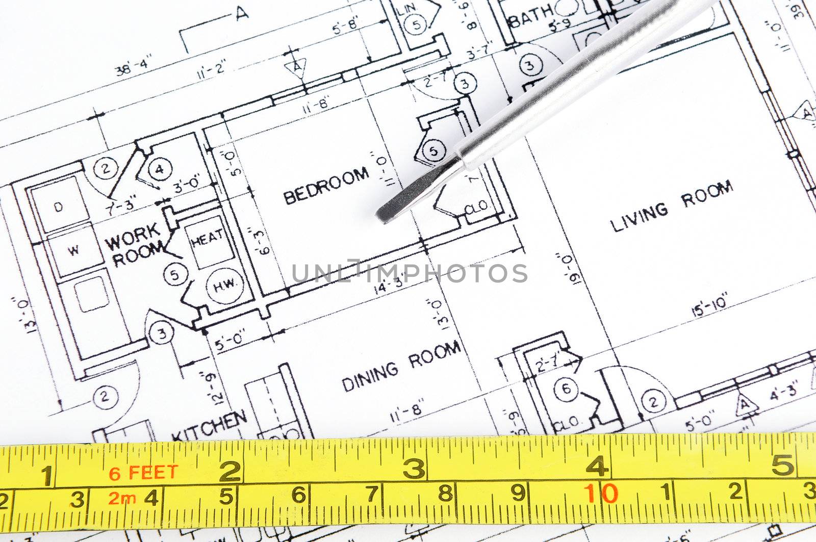 House blueprint with a measuring tape and a screwdriver on top of it