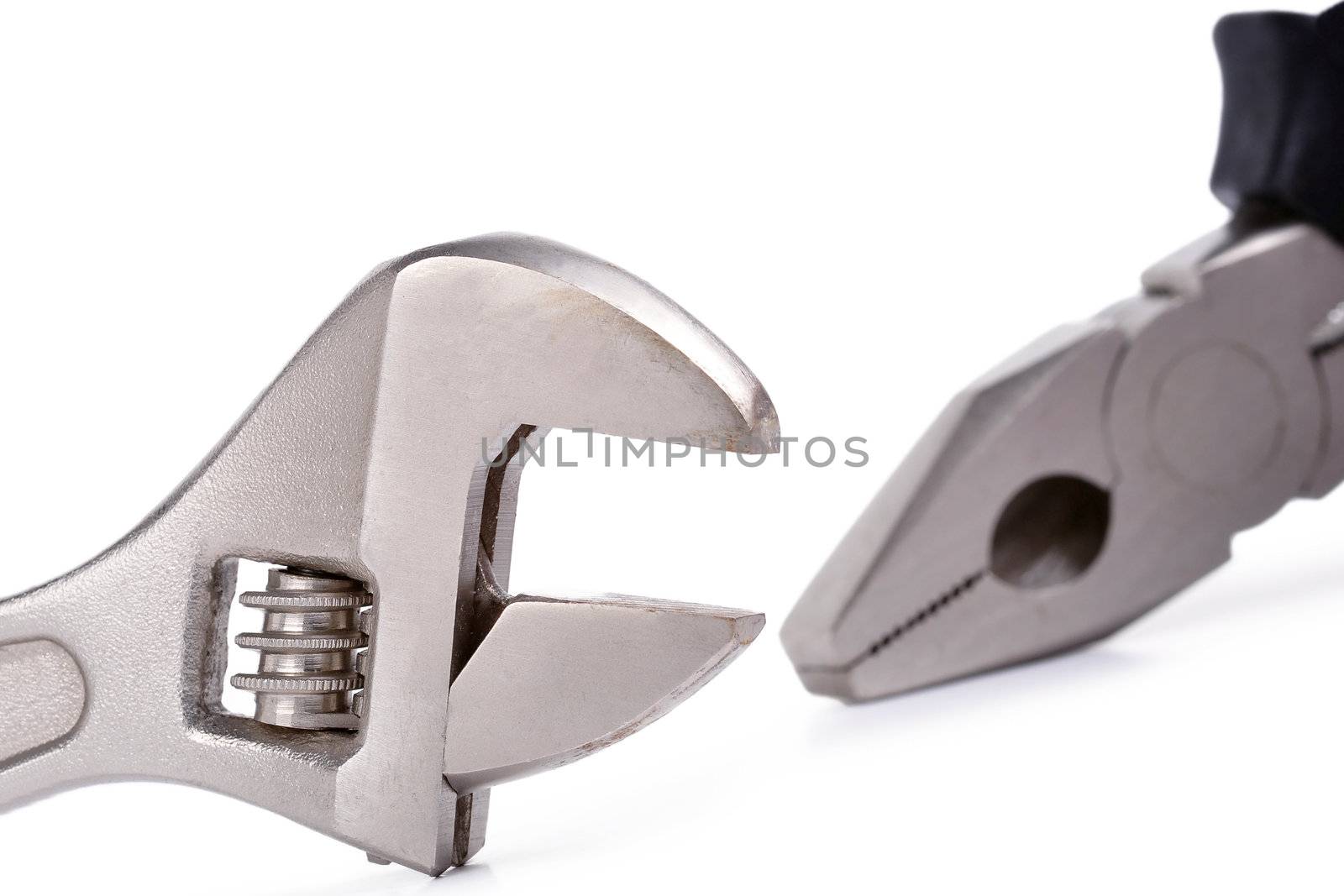 Closeup of a wrench and a pliers on a white background
