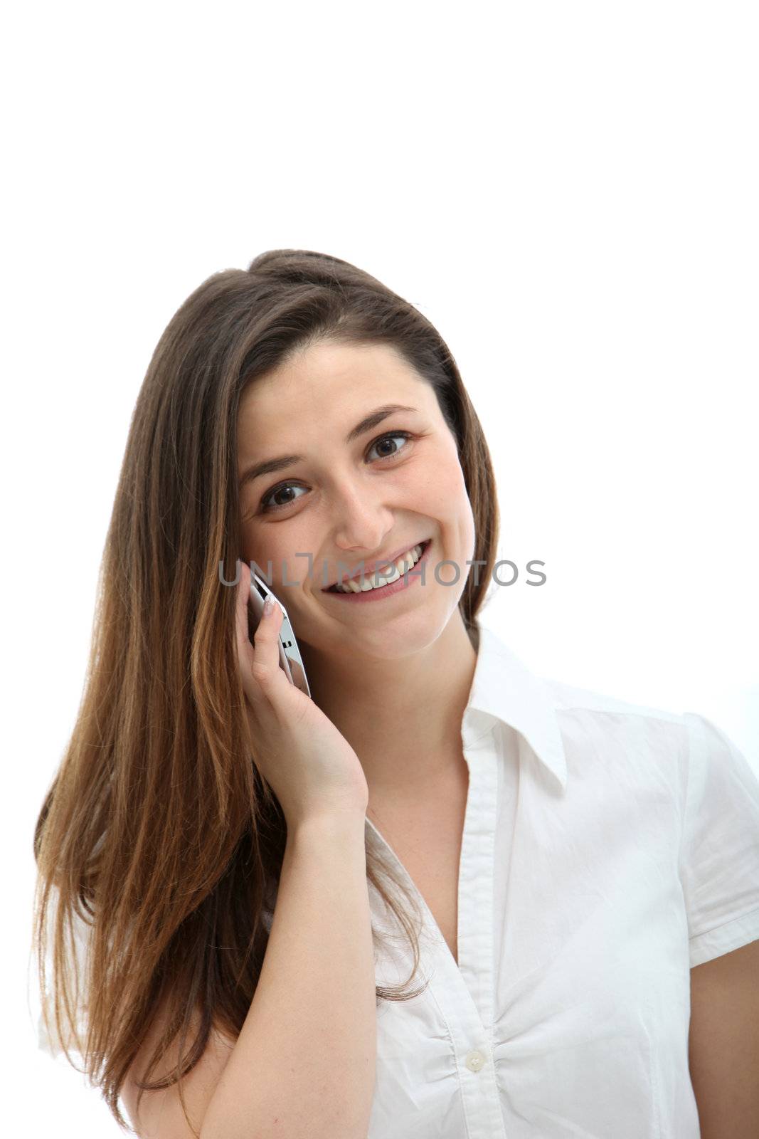 Pretty young woman with long brunette hair and a natural smile talking on her mobile