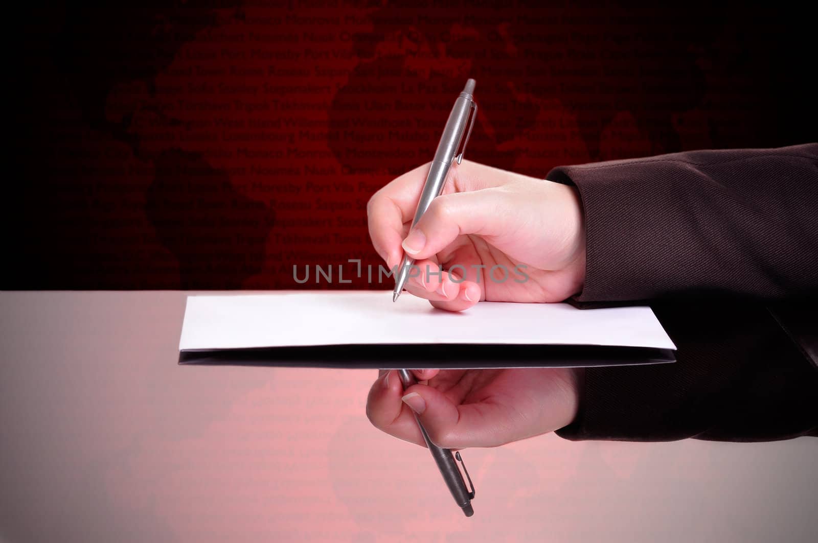 Businessperson writing a document with a world map behind