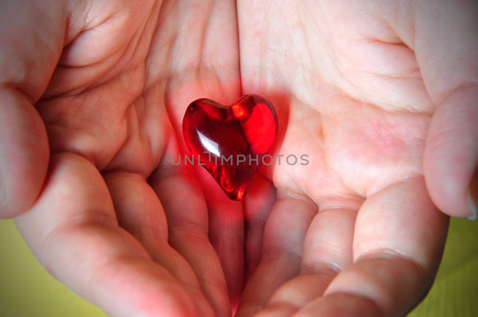 Glowing red heart hold on the palm of one's hands
