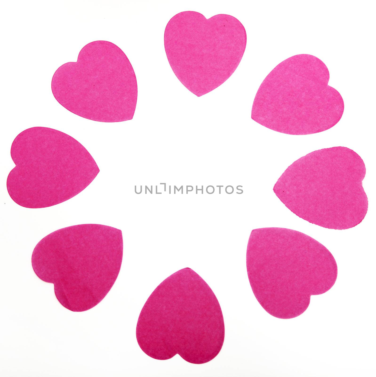 Circle of pink hearts on white background