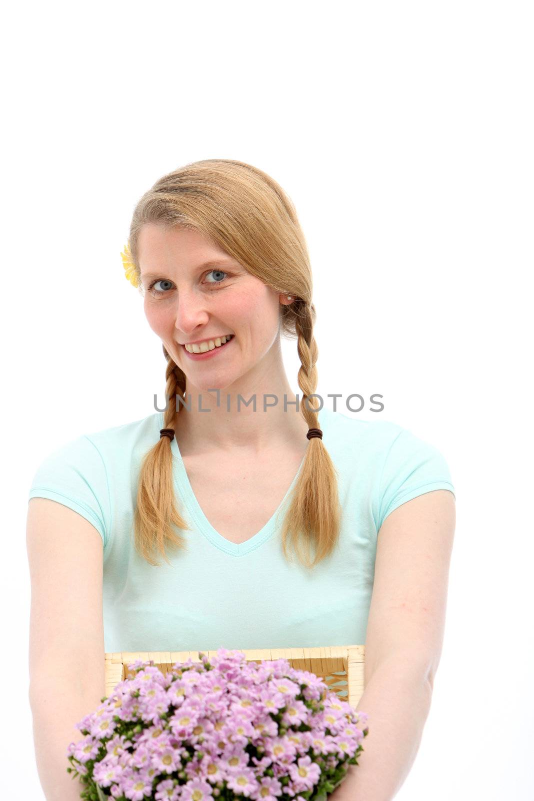 Smiling blond female holding pink flowers on white background