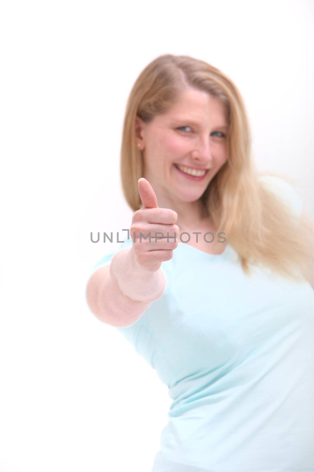 Happy blonde woman giving thumbs up of success and approval with selective focus to her hand