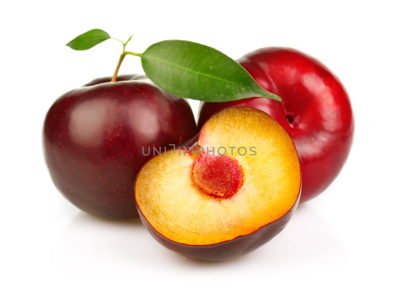 Ripe plums fruit with slices isolated on white background