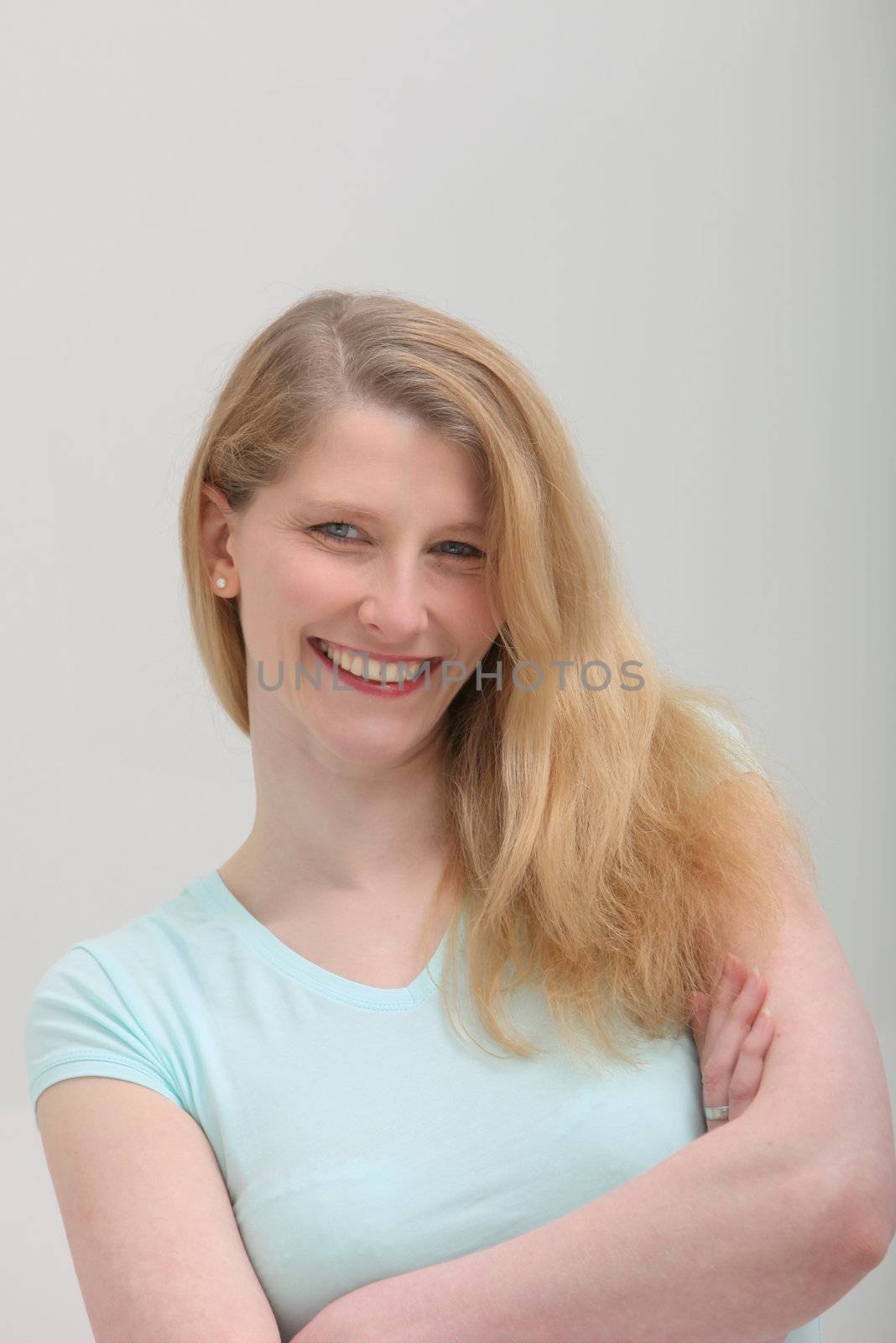 Portrait of smiling blond female on grey background