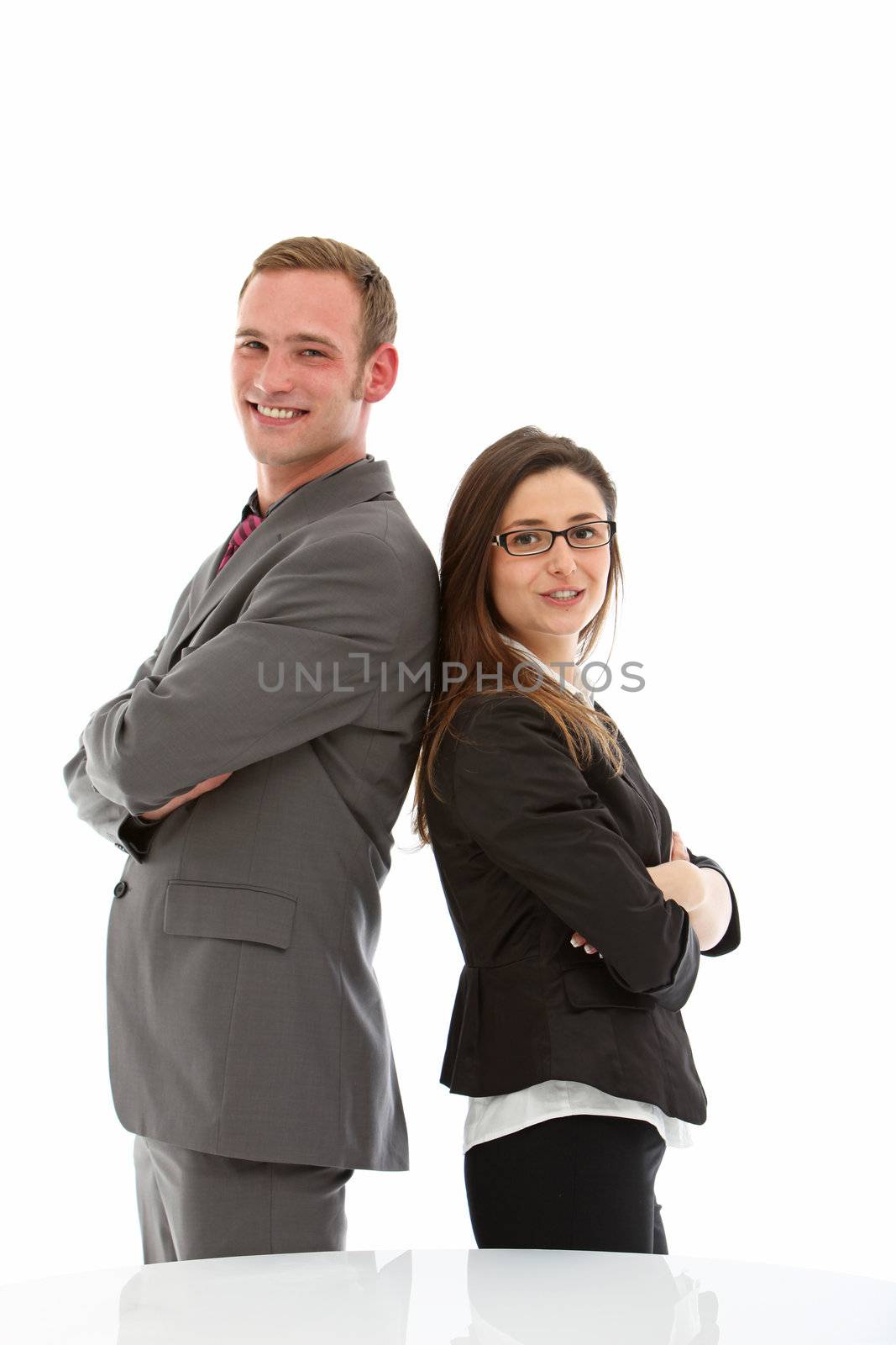 Smiling man and woman in suits standing back to back on white background