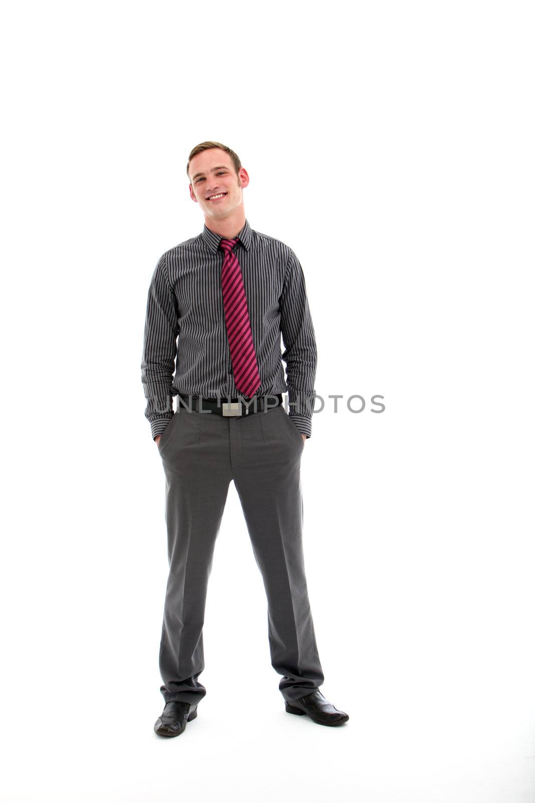 Confident casual smiling handsome businessman in stylish outfit posing full length facing camera with his hands in his pockets isolated on white