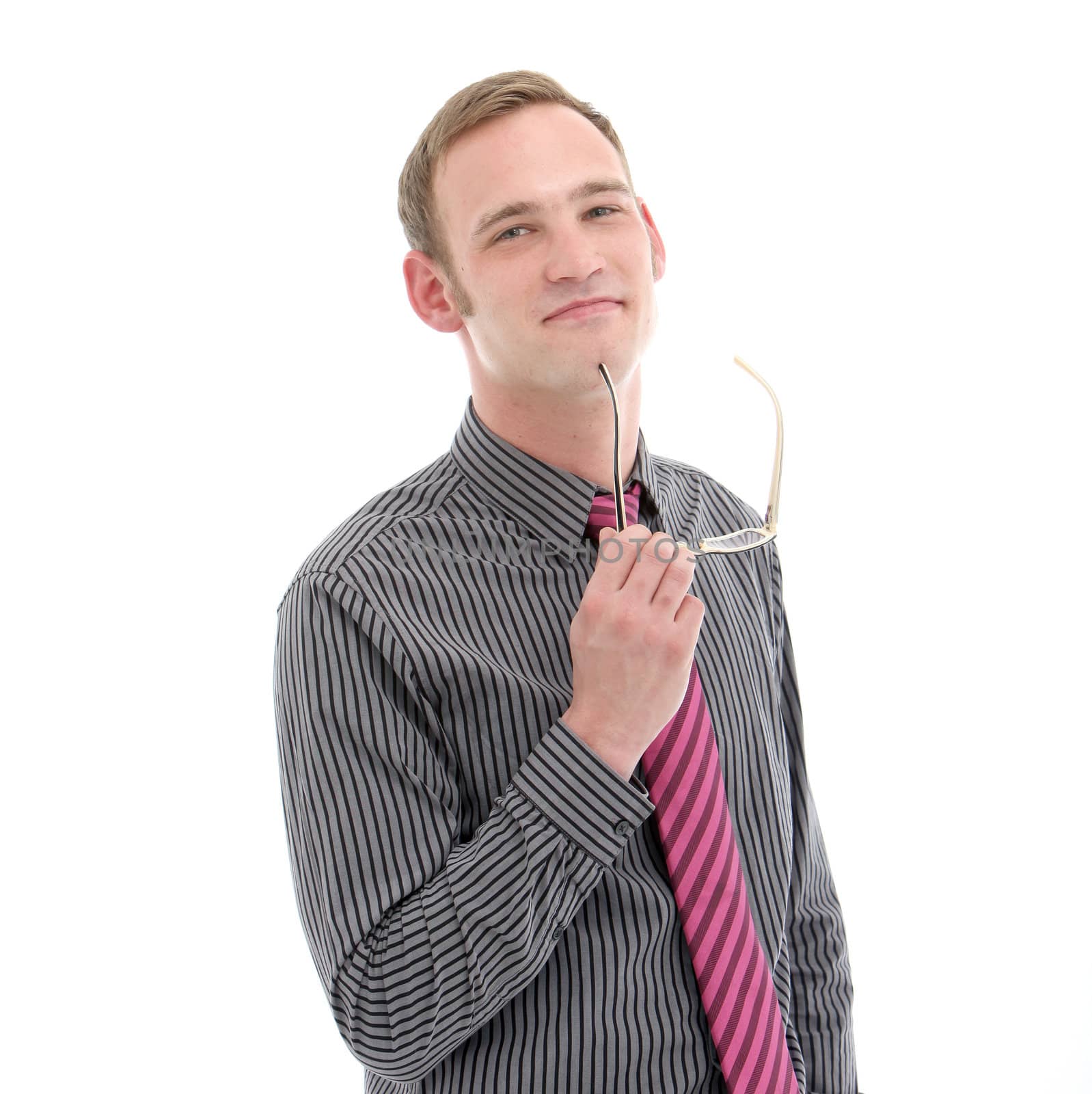 Thoughtful stylish young businessman standing with his glasses in his hands staring contemplatively at the camera as he assesses his decisions