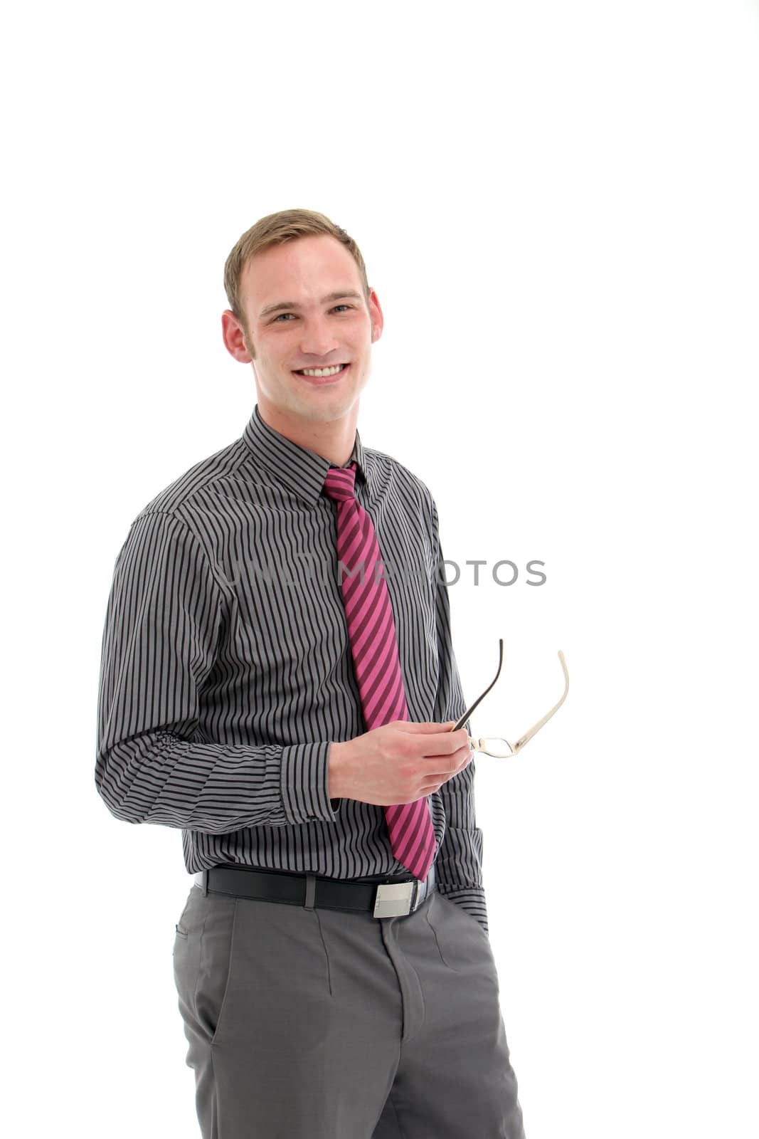 Handsome smiling young businessman in three quarter pose with his glasses in his hand isolated on white