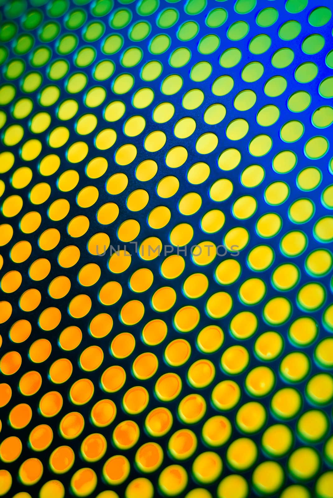 A metalic reflective surface back lit by a colorful light.