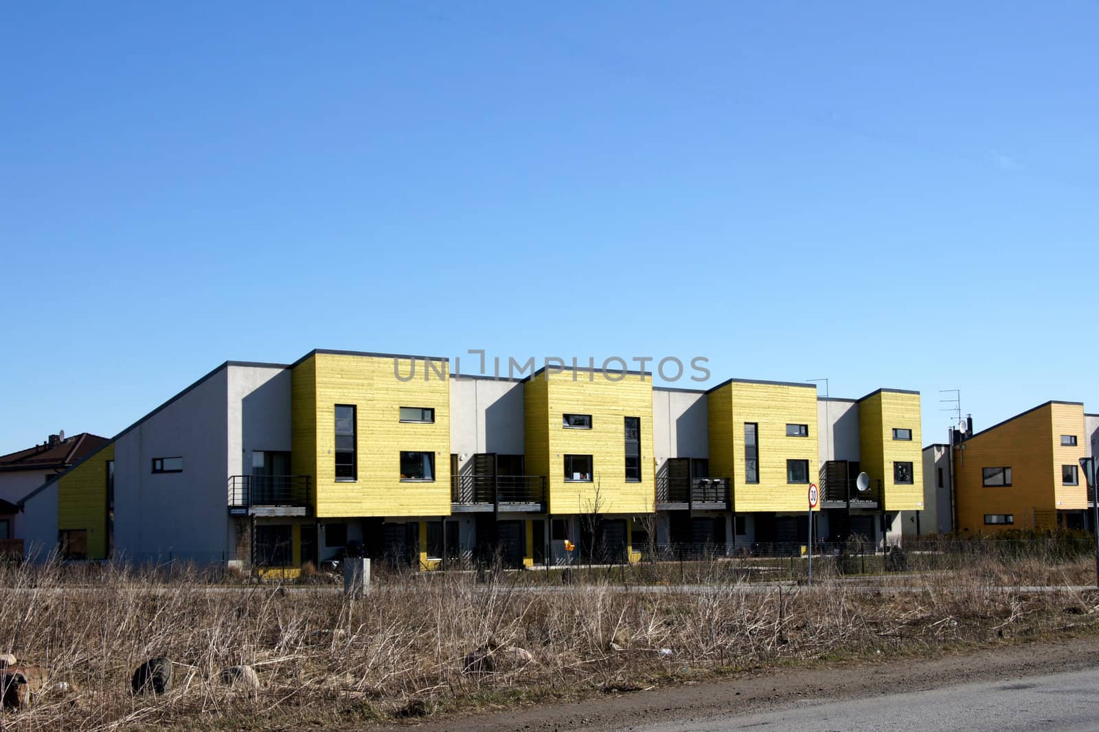 Modern apartment house on a background of a green grass and trees