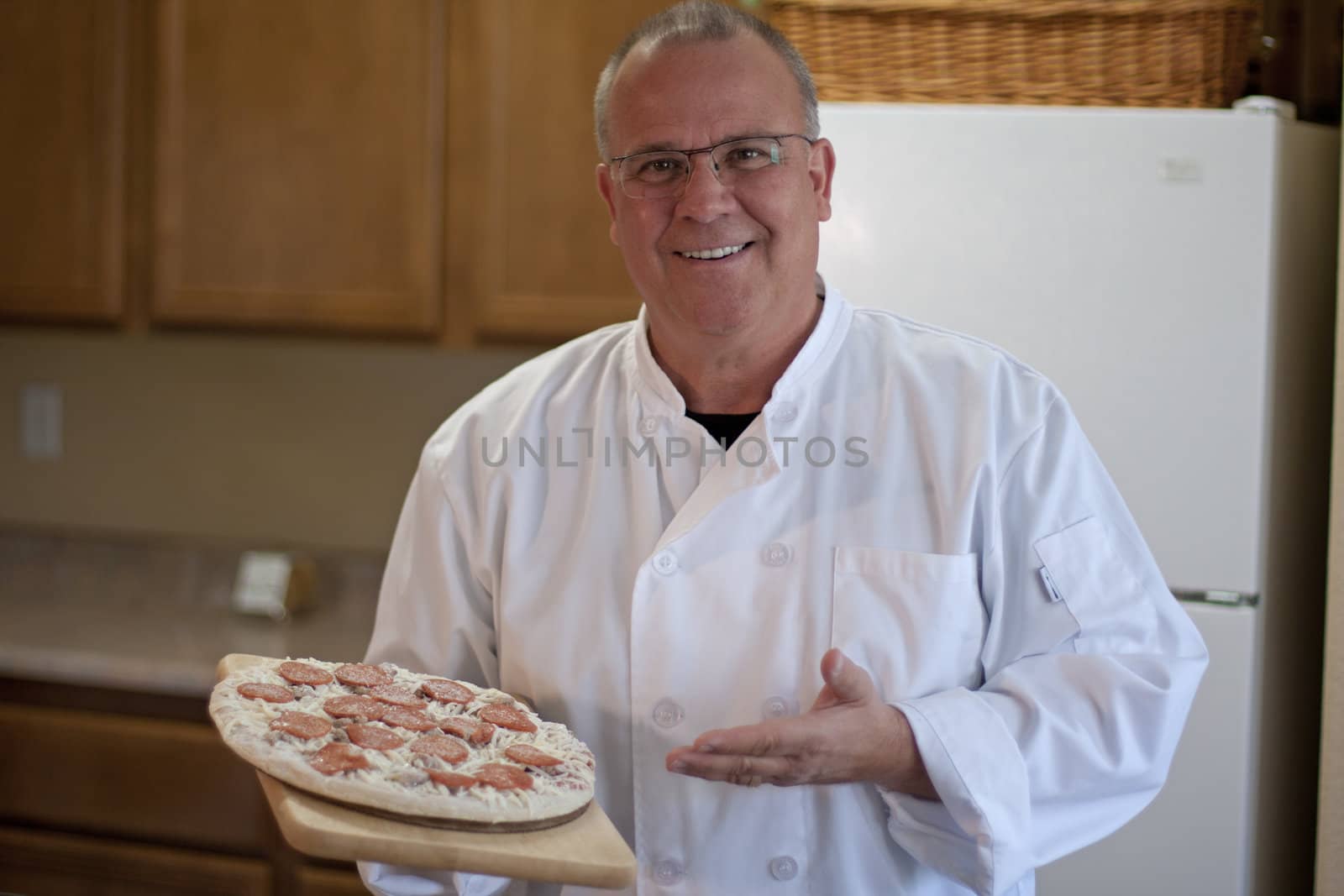 chef with frozen pizza in kitchen presenting