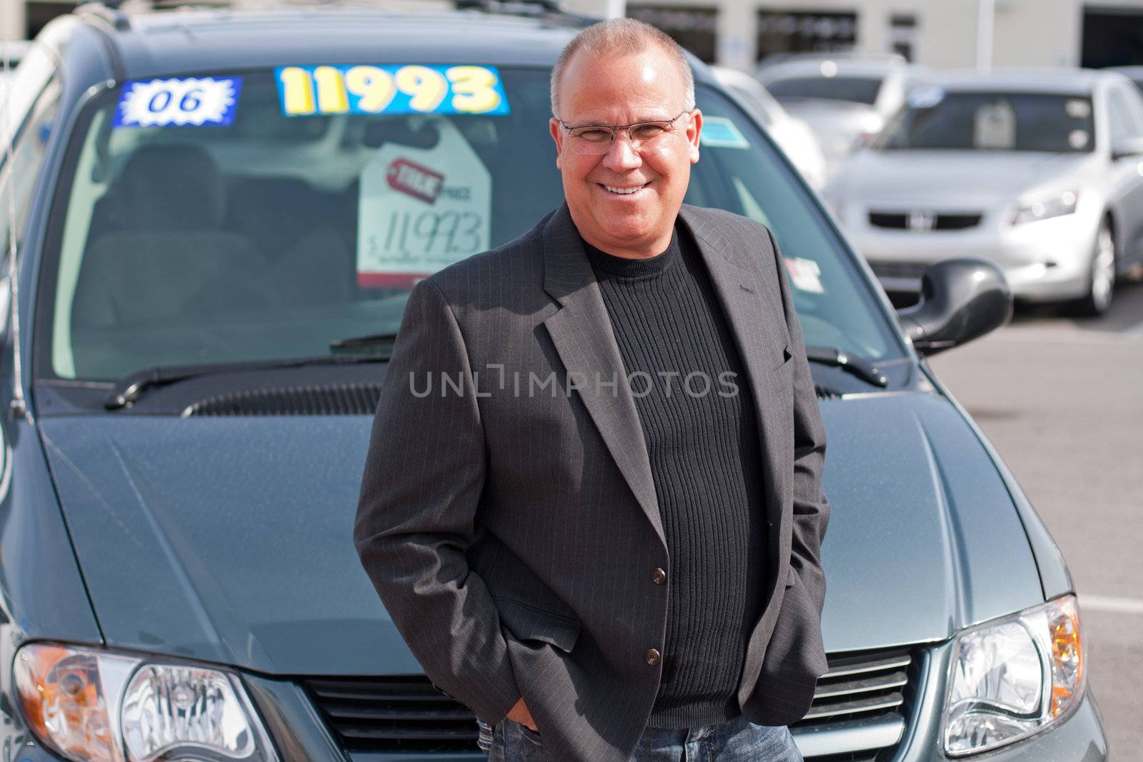 car salesman on lot with price sticker on cae selling