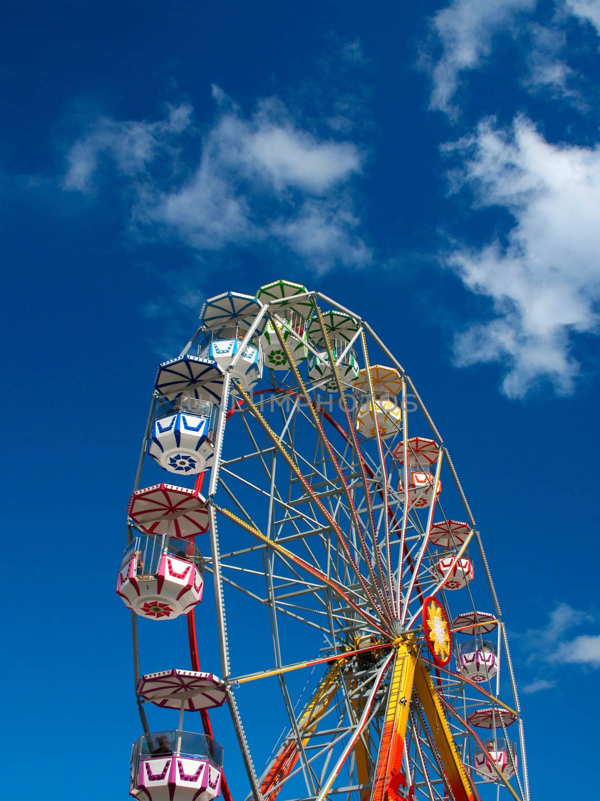 Colorful Ferris wheel against blue summer sky background