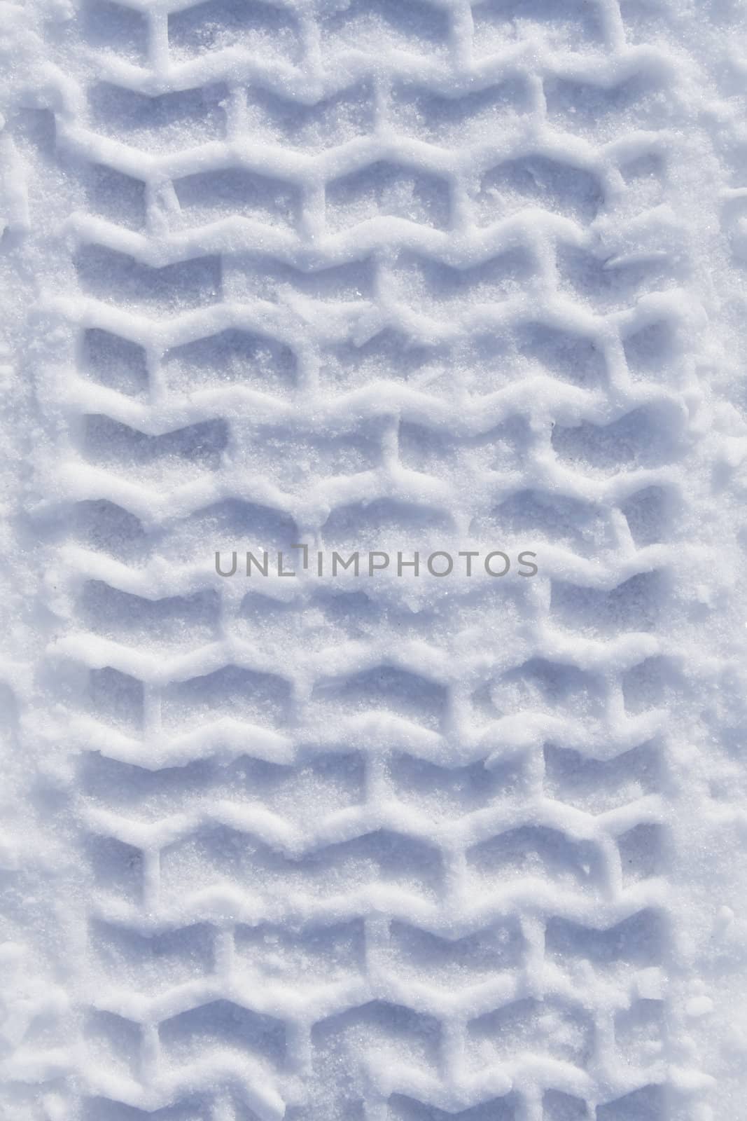 Track of heavy vehicle tire in pure white snow