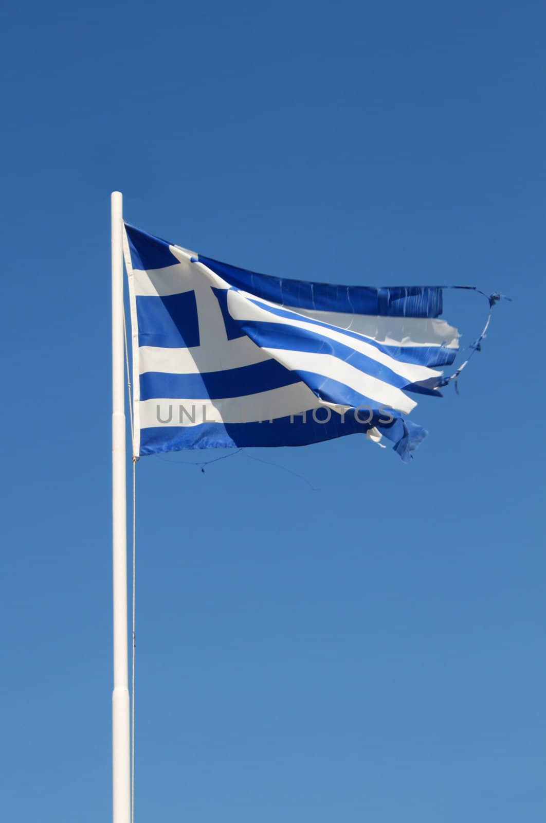 Ragged flag of Greece waving in wind vertical