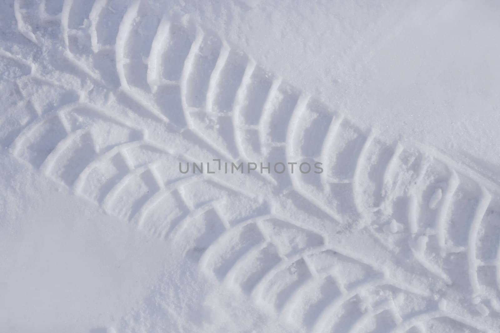 Diagonal track of car tire in pure white snow