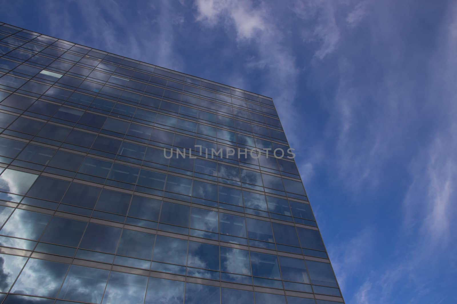 Picture of a tall buildning with reflections from the sky