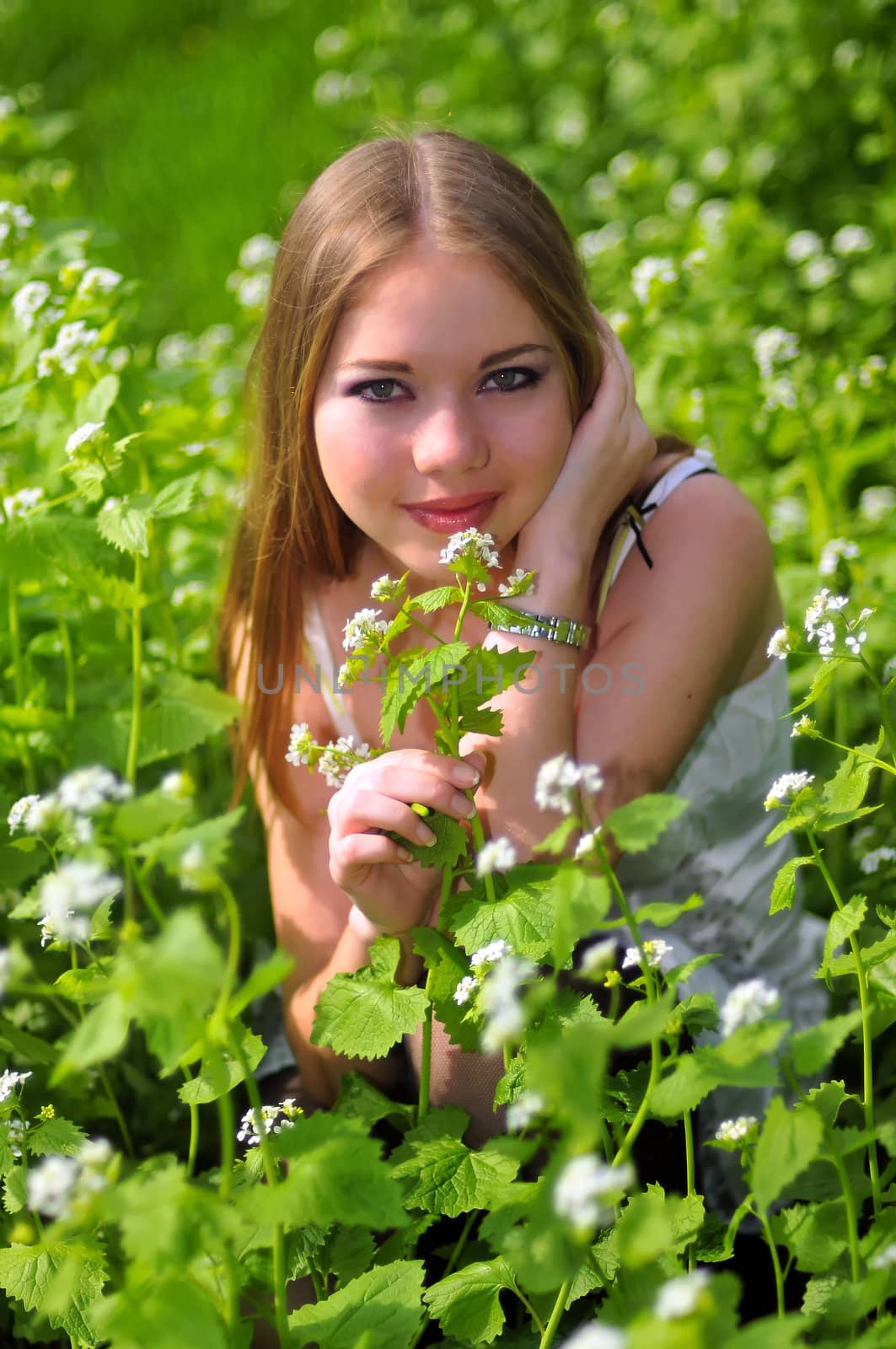 young girl is sitting on green grass