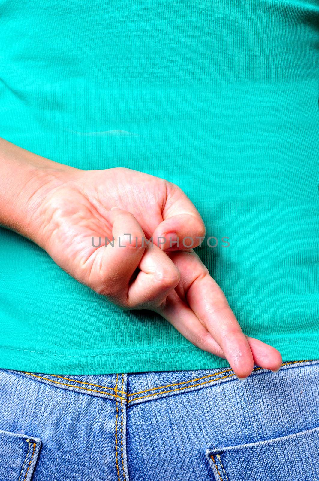 Close up of crossed fingers behind a woman's back