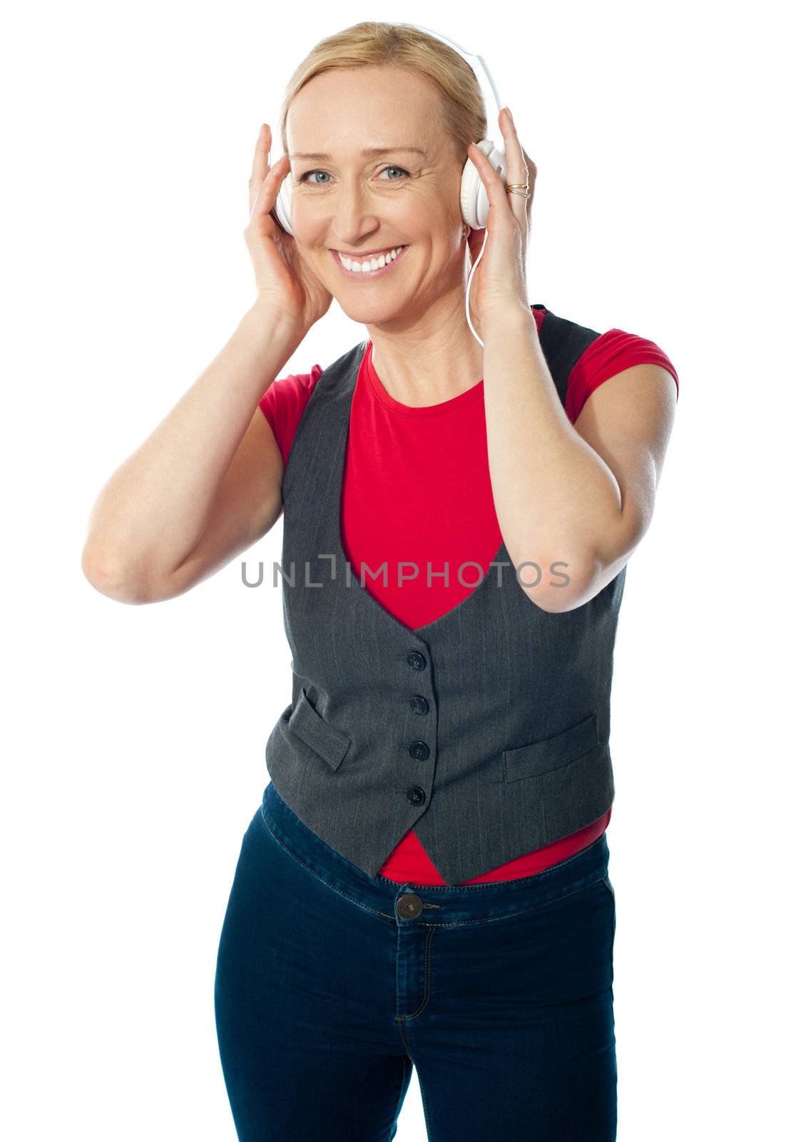 Aged female enjoying music on her music player by stockyimages