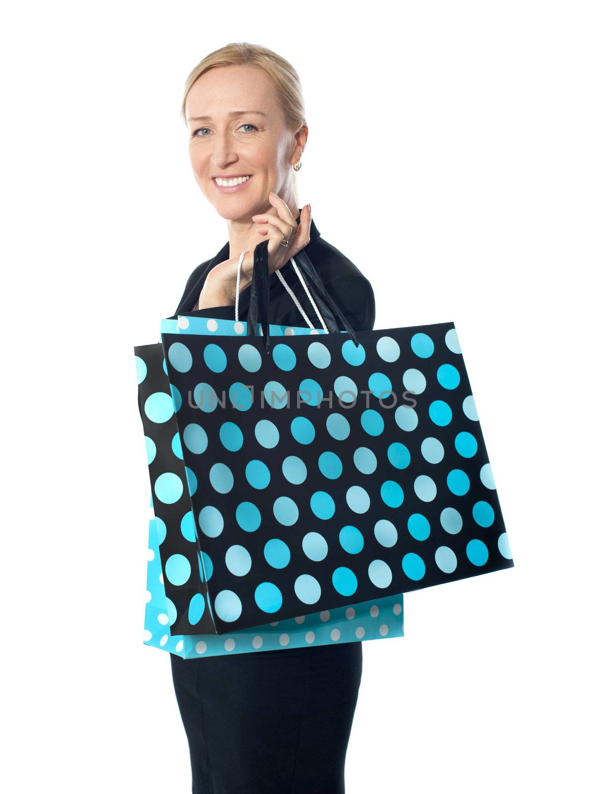 Senior woman posing with dotted shopping bag holding it on her shoulders