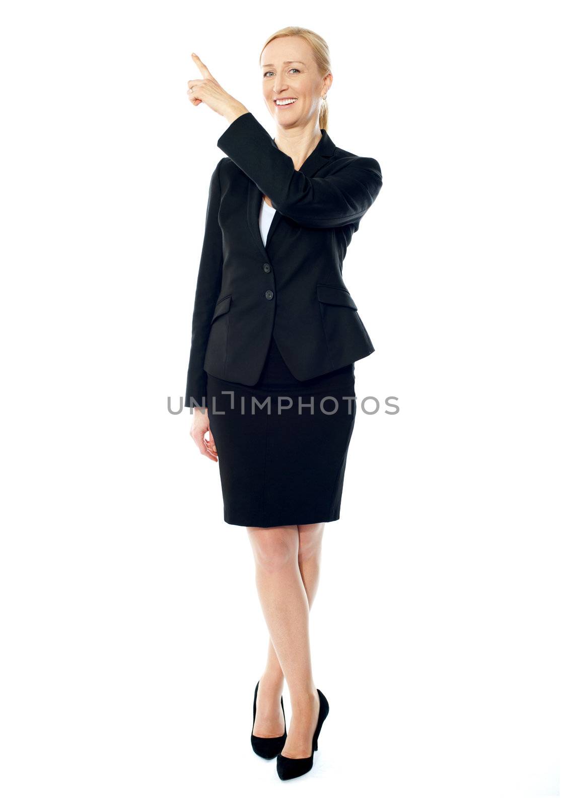 Business lady pointing upwards, copyspace concept by stockyimages