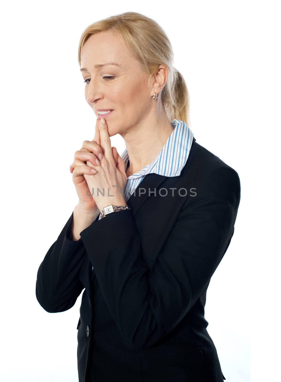 Senior corporate woman posing with fingers on her lips, looking downwards