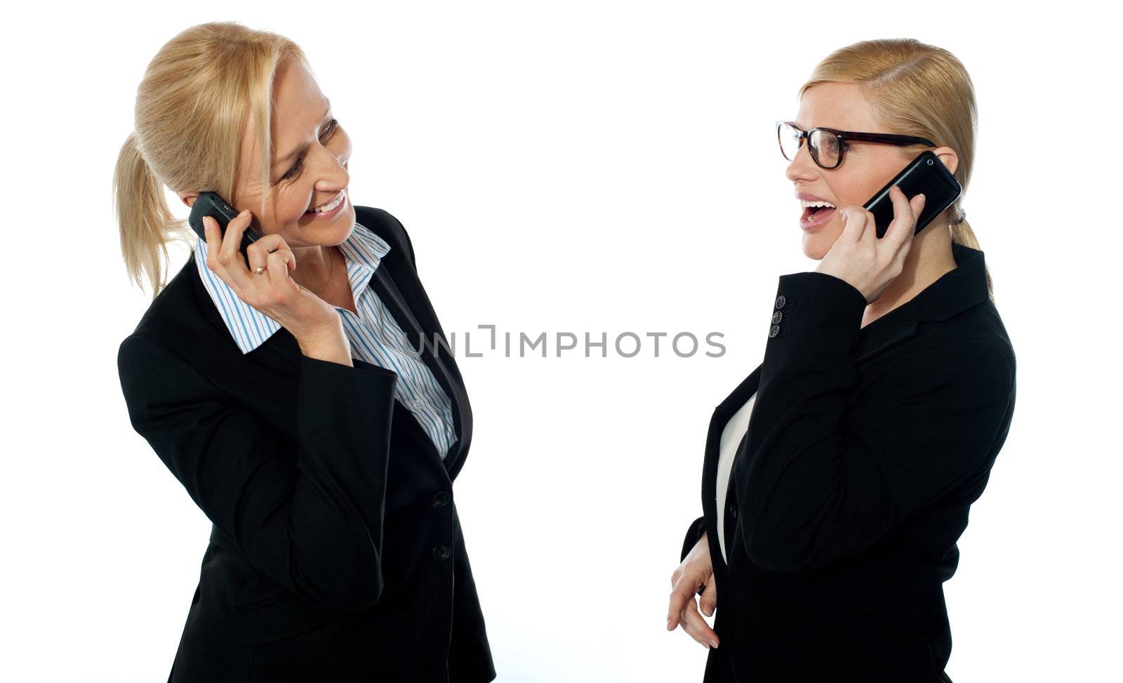 Businesswomen communicating via mobile phones isolated on white background