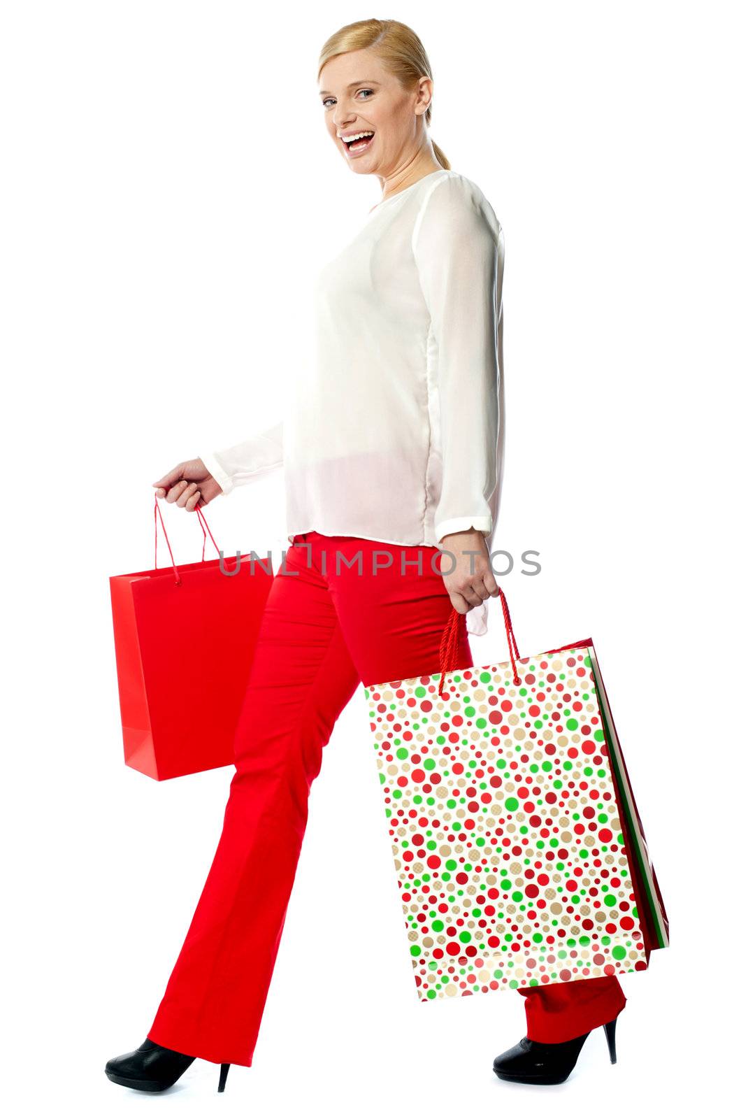Pretty woman with shopping bags, walking. Isolated on white background