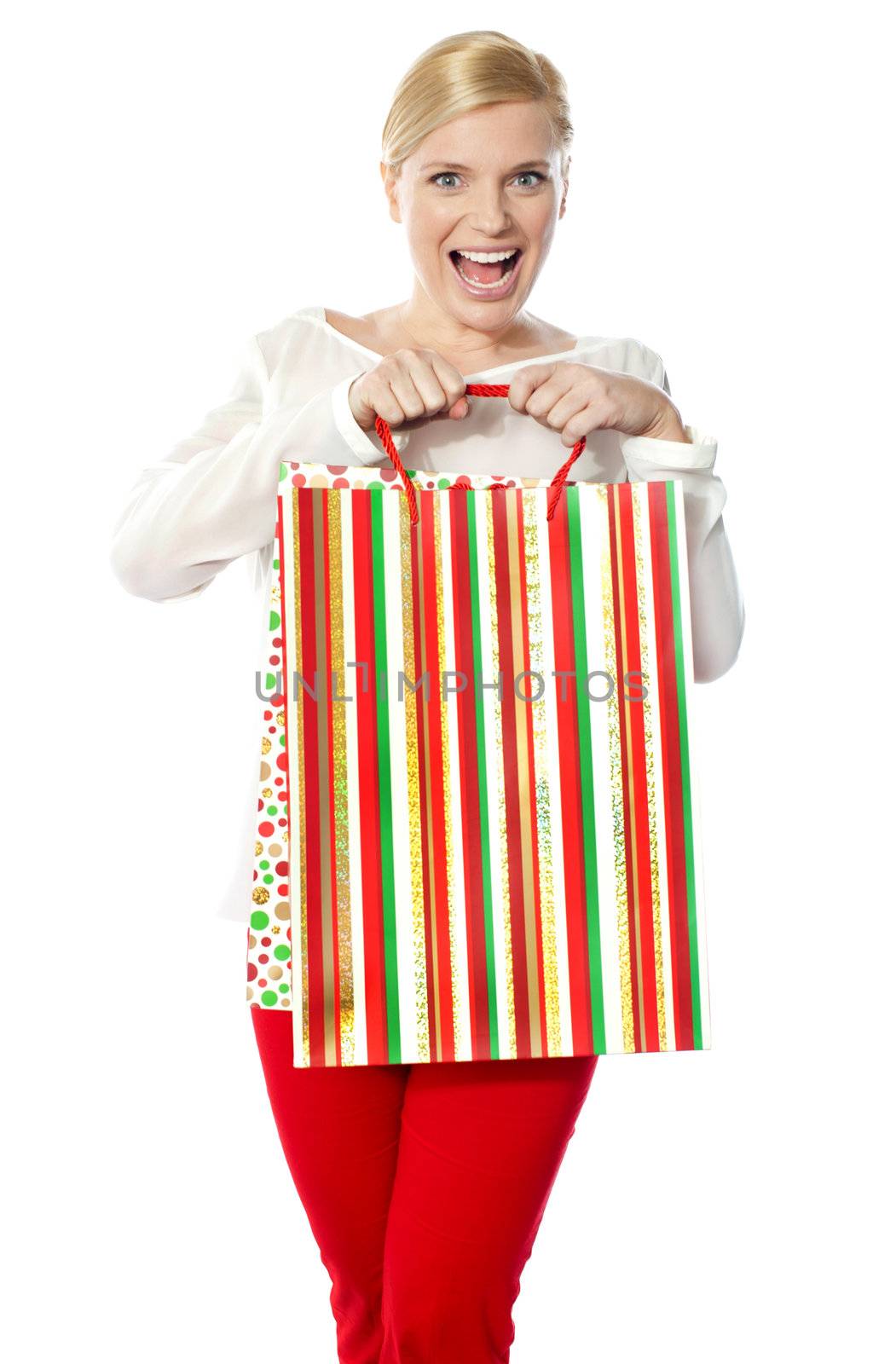 Happy shopping woman holding bag by stockyimages