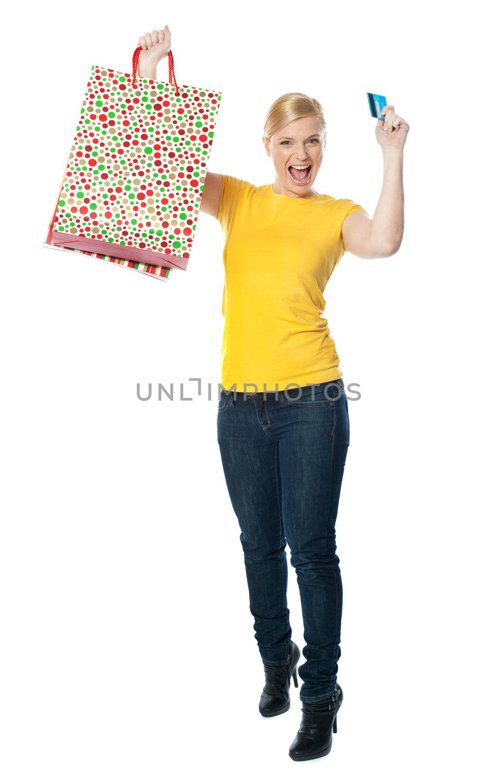 Excited teenager holding shopping bag and card by stockyimages