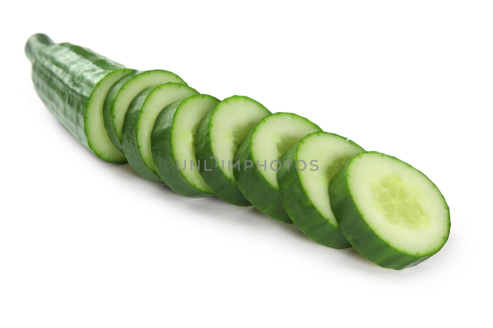 Photo of a cucumber cut into thick slices over a white background.