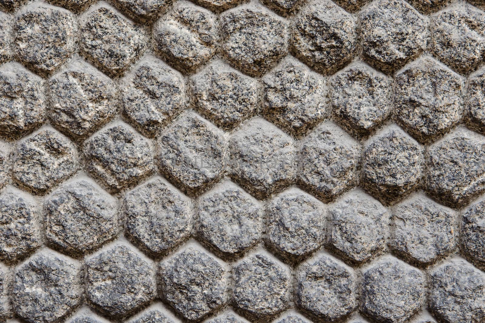 Texture of a wall with stones and masonry shaped of hexagons