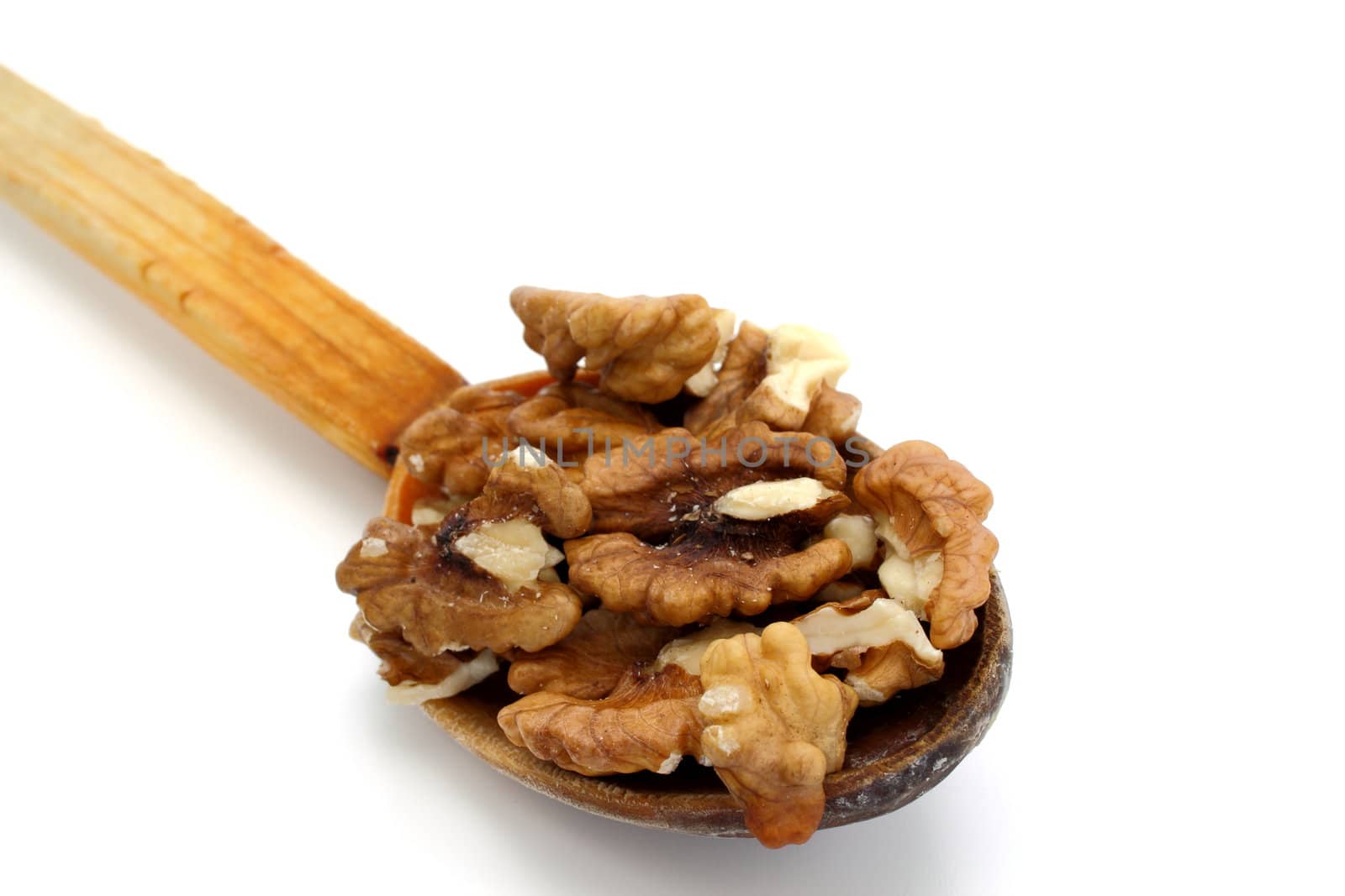 wooden spoon with walnuts over white background