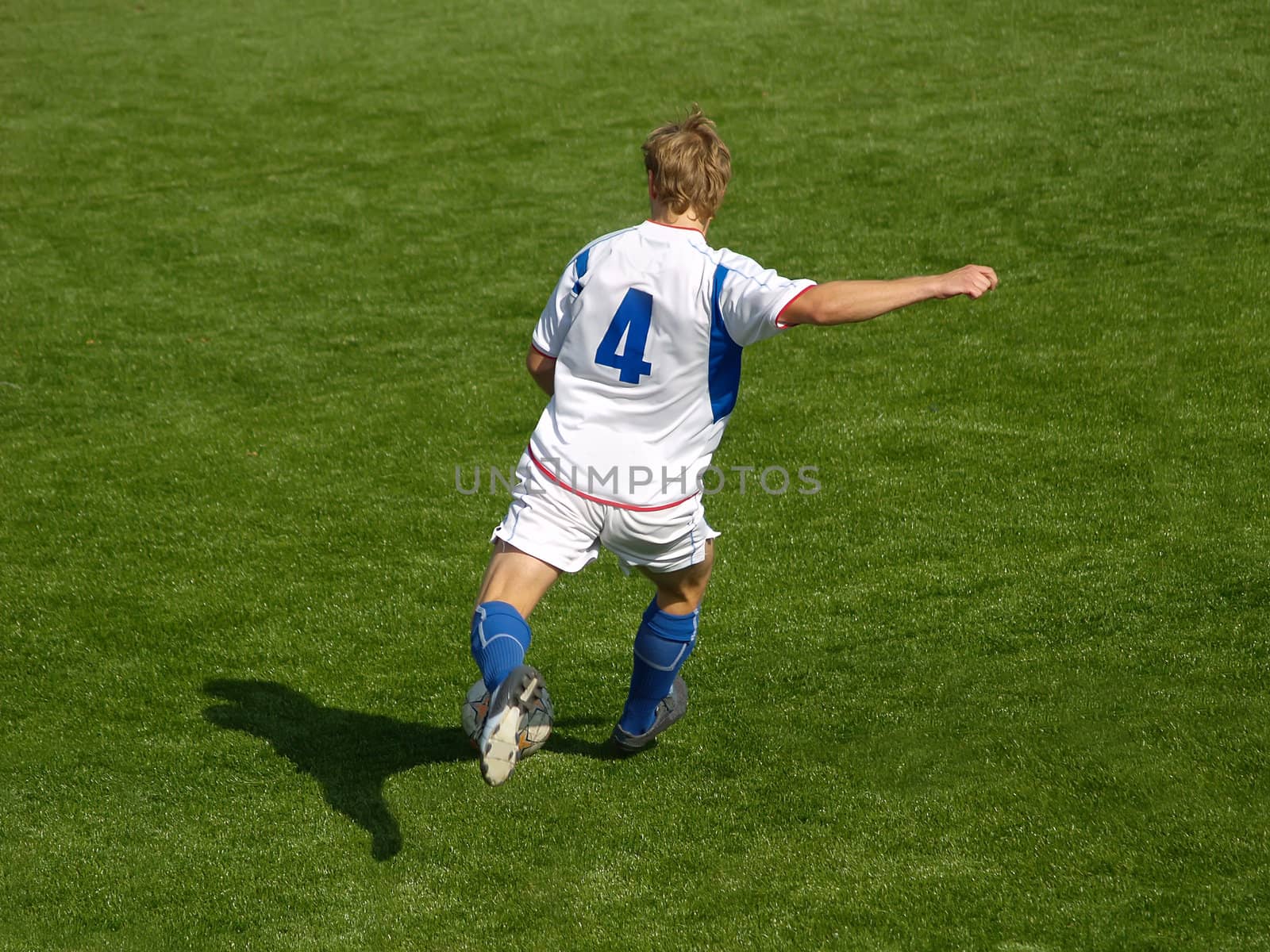 Football player shooting the ball in attack