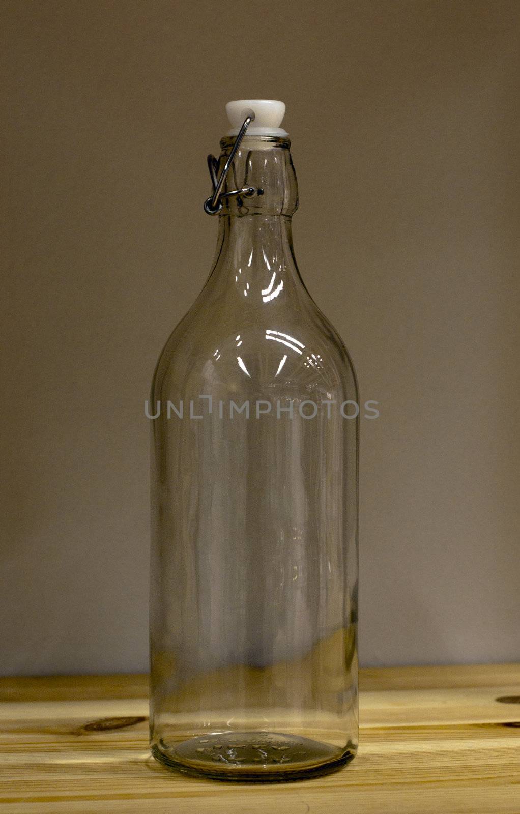 transparant bottle on a wooden shelf by compuinfoto