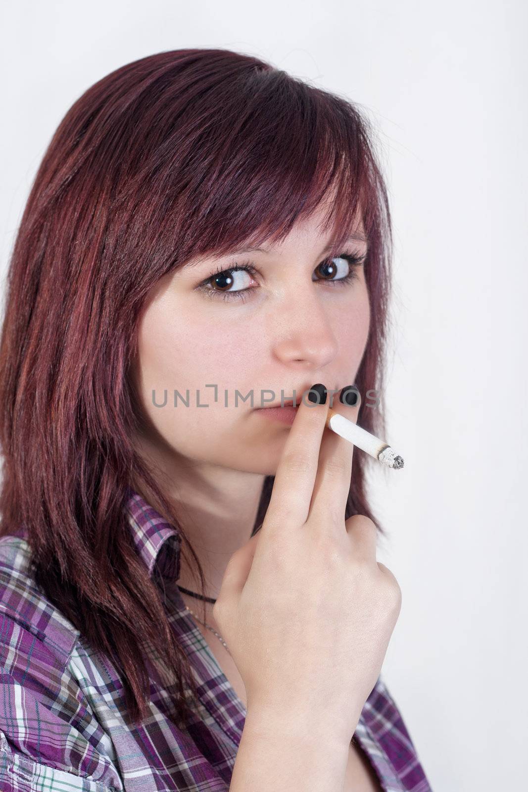 young redhead woman is smoking a cigarette - isolated on white background
