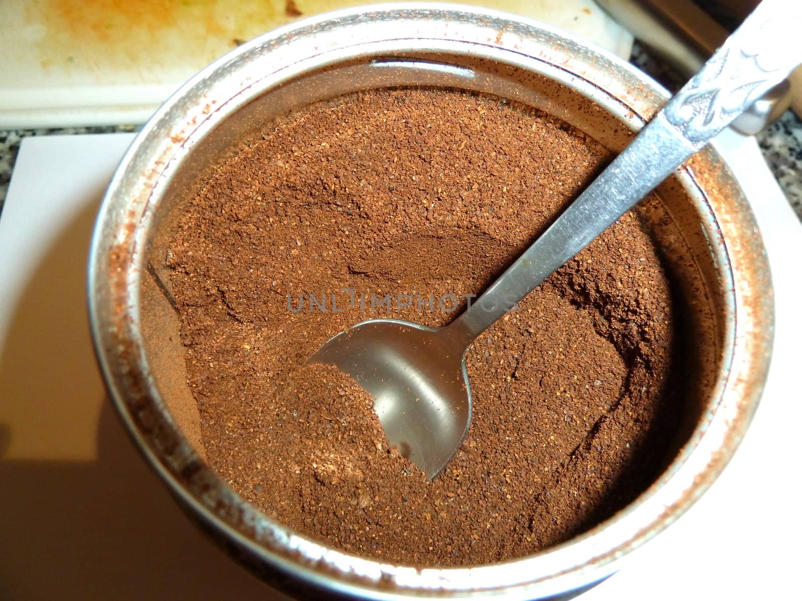 coffee grounds and spoon in a storage container