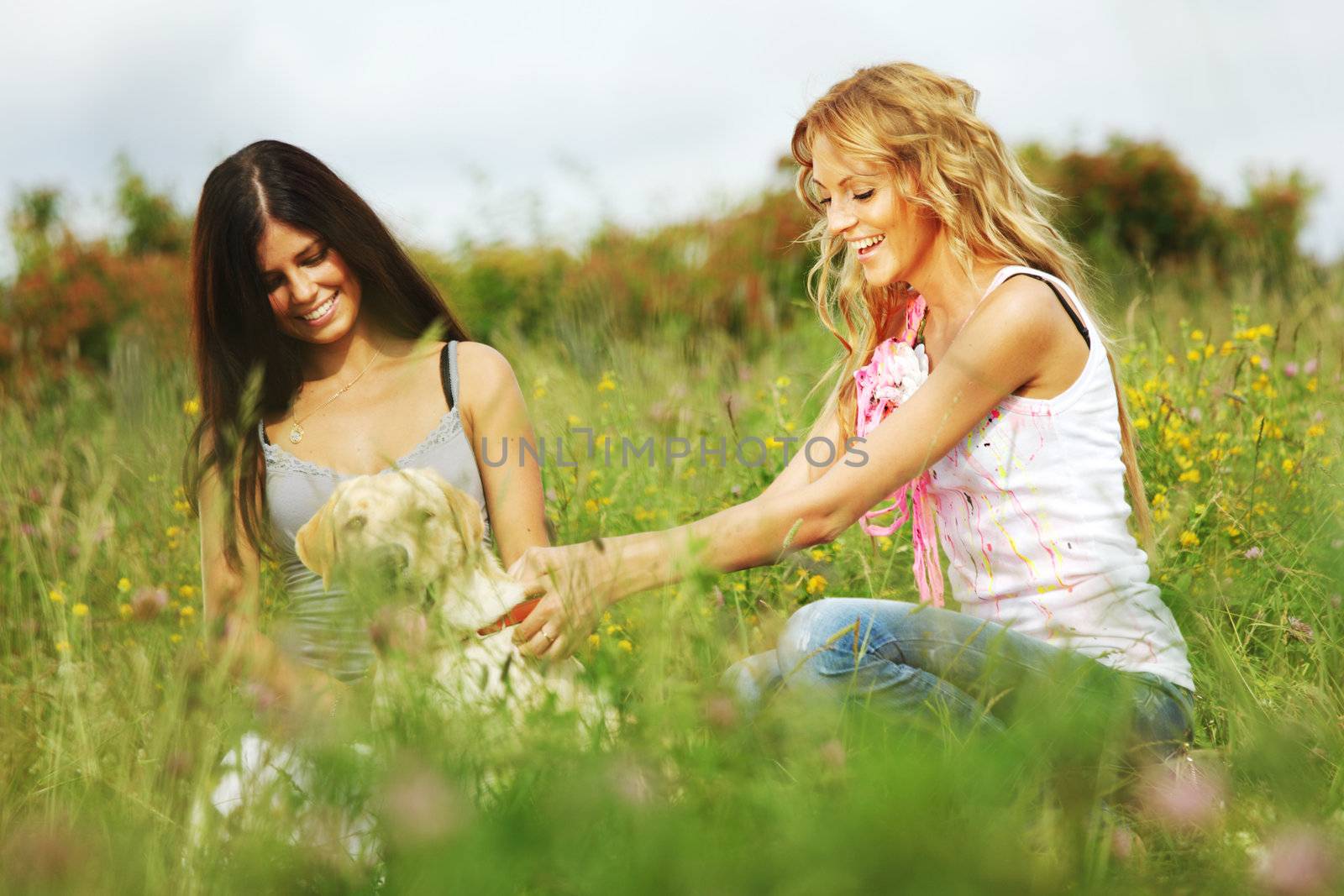 girlfriends and dog in green grass field