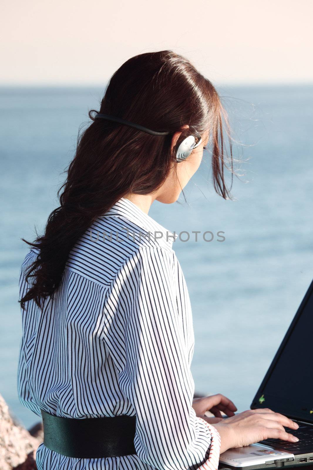 woman with laptop sea background