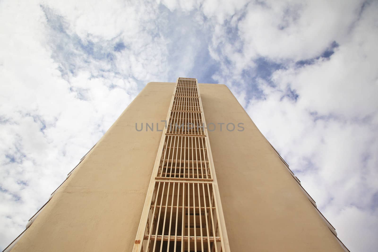 A high rise building against a cloudy blue sky.