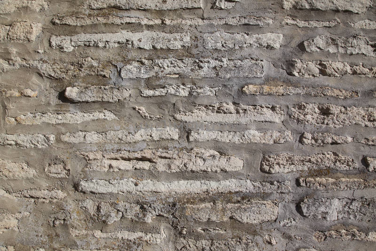 A grey and stained weathered brick wall, background.