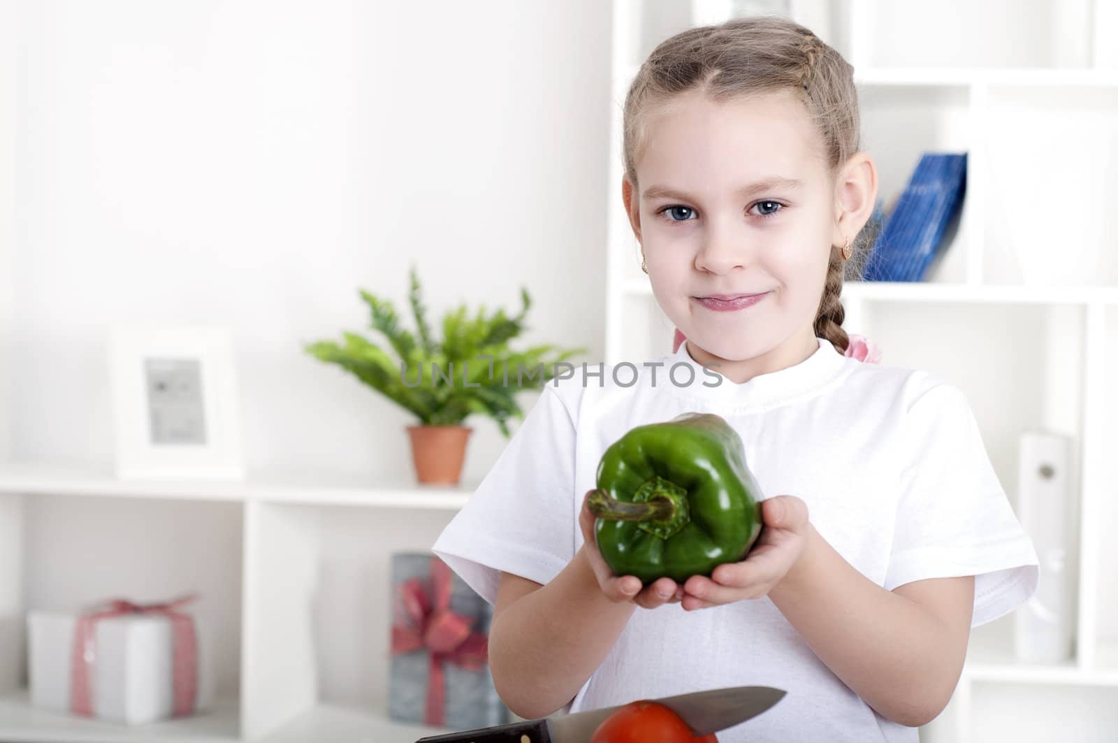 beautiful girl in the kitchen cooking vegetables