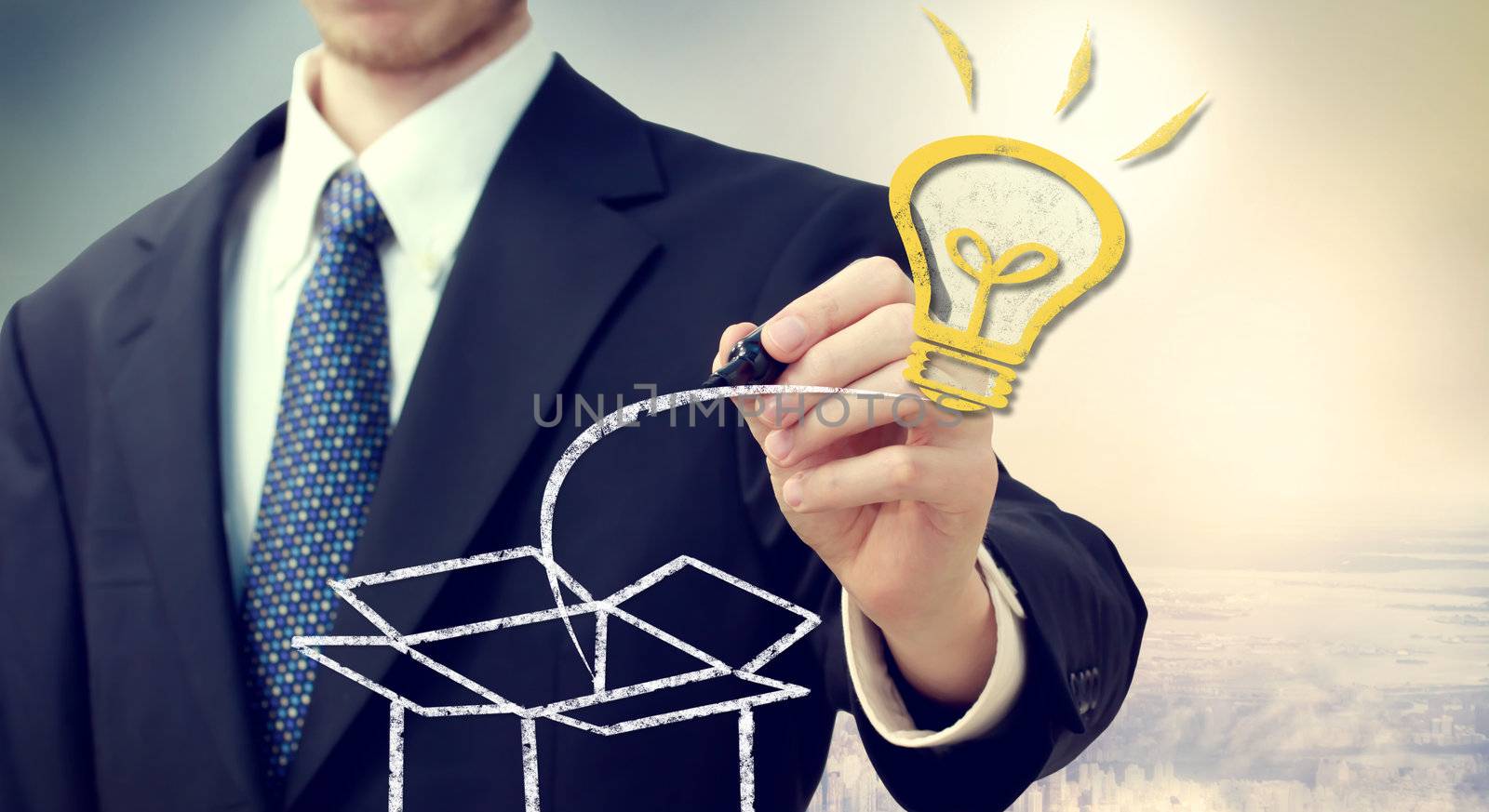 Business man with Idea light bulb coming 'out of the box' with a big city backdrop