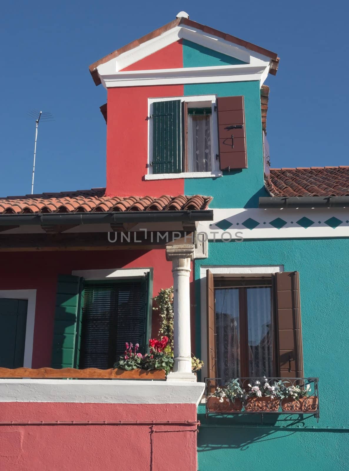 Brightly-colored house with the island of Burano in Italy