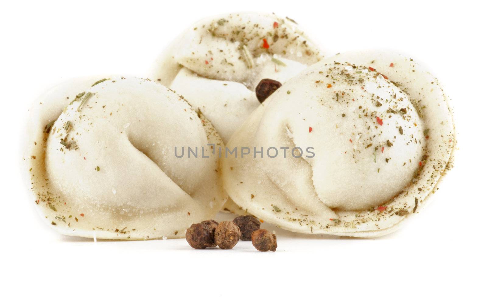 Three handmede pelmeni with spices isolated on white background
