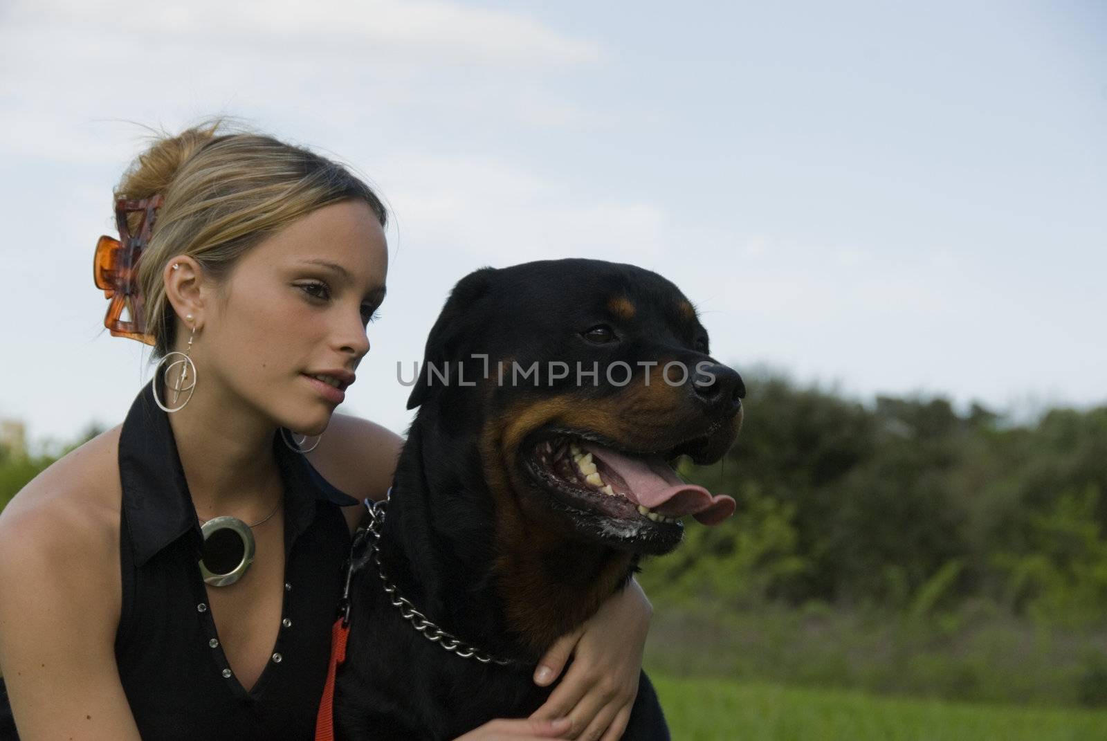 beautiful young womand and her purebred rottweiler